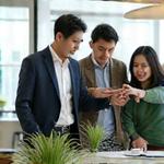 ノートパソコンと資料を広げ、真剣な表情で話し合うブランド戦略コンサルタントチームのイメージ